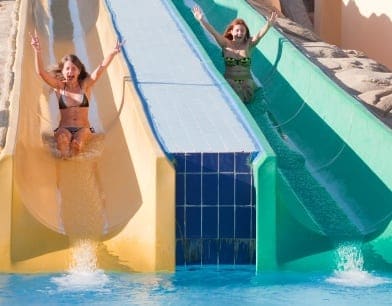 Two teenagers sliding on a water ride