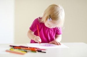 Little girl coloring on paper in a cabin