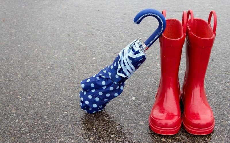 Red rain boots and an umbrella outside