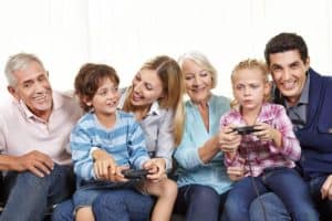 Entire family laughing and playing video games from the couch