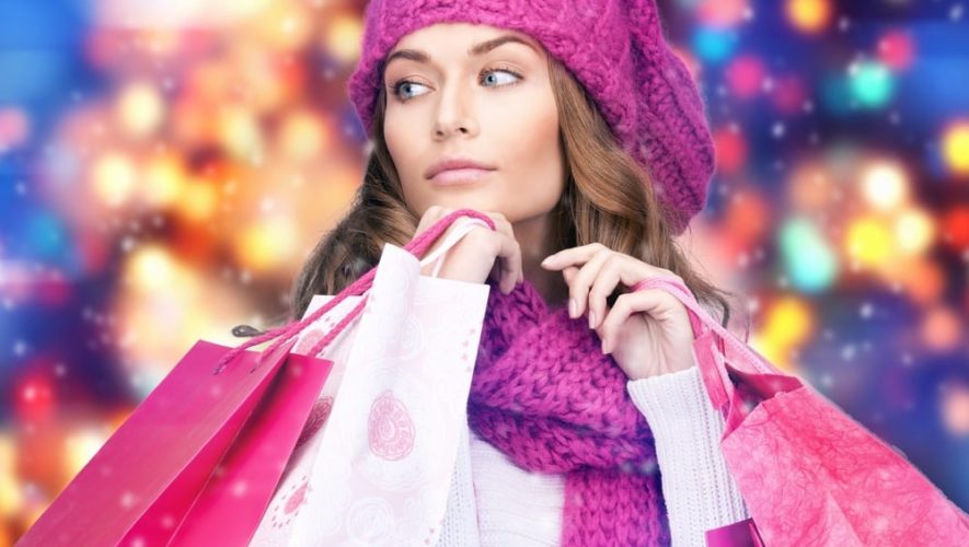 Girl shopping with pink shopping bags in the winter