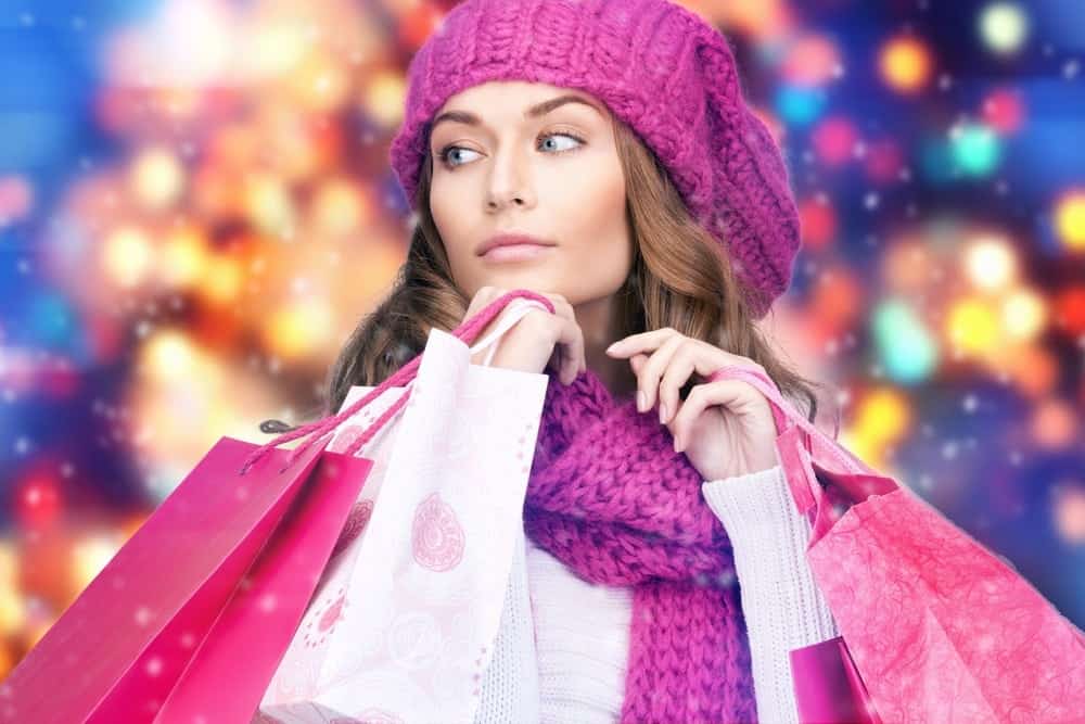 Girl shopping with pink shopping bags in the winter