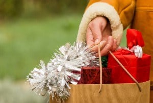 Person holding shopping bag of Christmas gifts