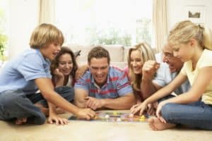 Family playing a board game together on the floor
