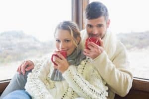 Romantic couple smiling and sipping a hot drink in a Gatlinburg cabin