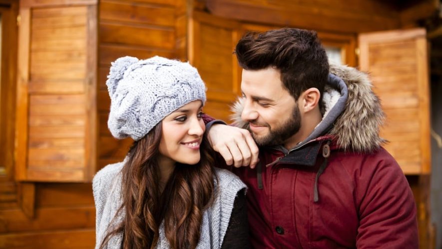 Happy couple in winter clothing outside one of our romantic cabins in Gatlinburg.