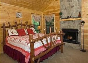 The bedroom in the Paradise Cove cabin with a fireplace.