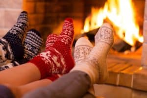Three feet in wool socks in front of the fireplace.