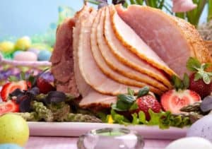An Easter ham with fruit and decorations.
