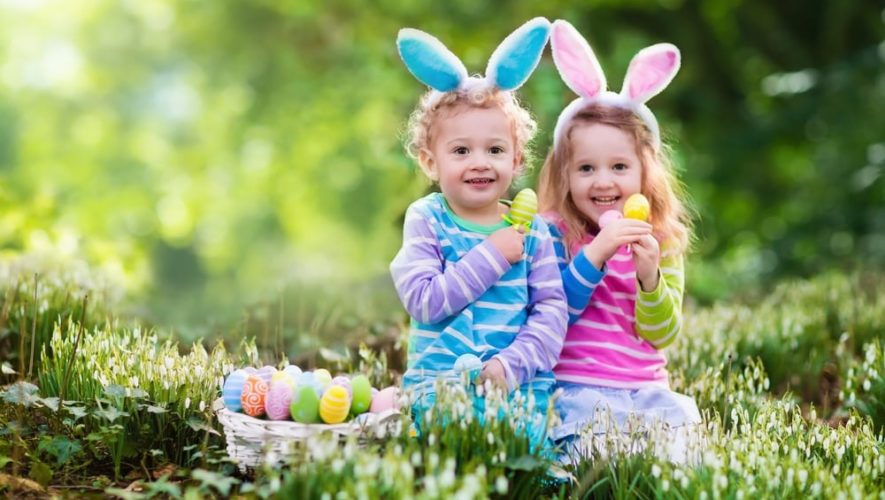 Little girls with Easter eggs and rabbit ears in the grass near our Great Smoky Mountain cabins.