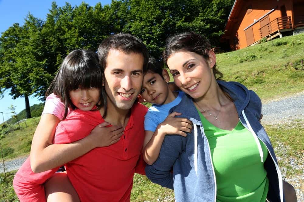 Happy family in front of a cabin rental.