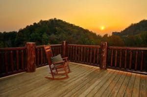 A rocking chair on the deck of a large group cabin in Gatlinburg TN with mountain views.