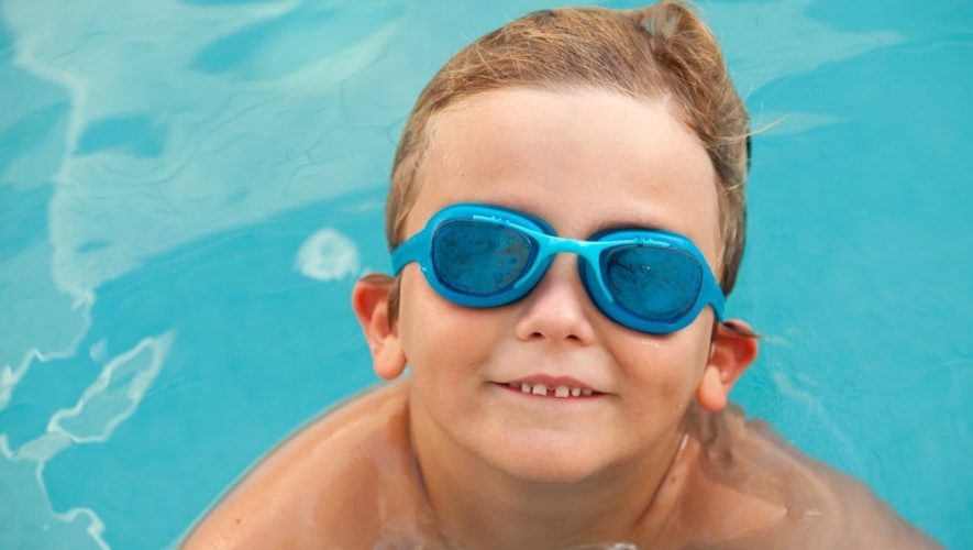 smiling little boy with blue goggles in pool at Smoky Mountain cabin