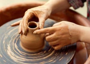 Someone making pottery on a wheel.