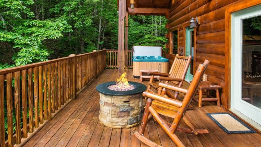 secluded cabin rentals deck with a firepit and rocking chairs