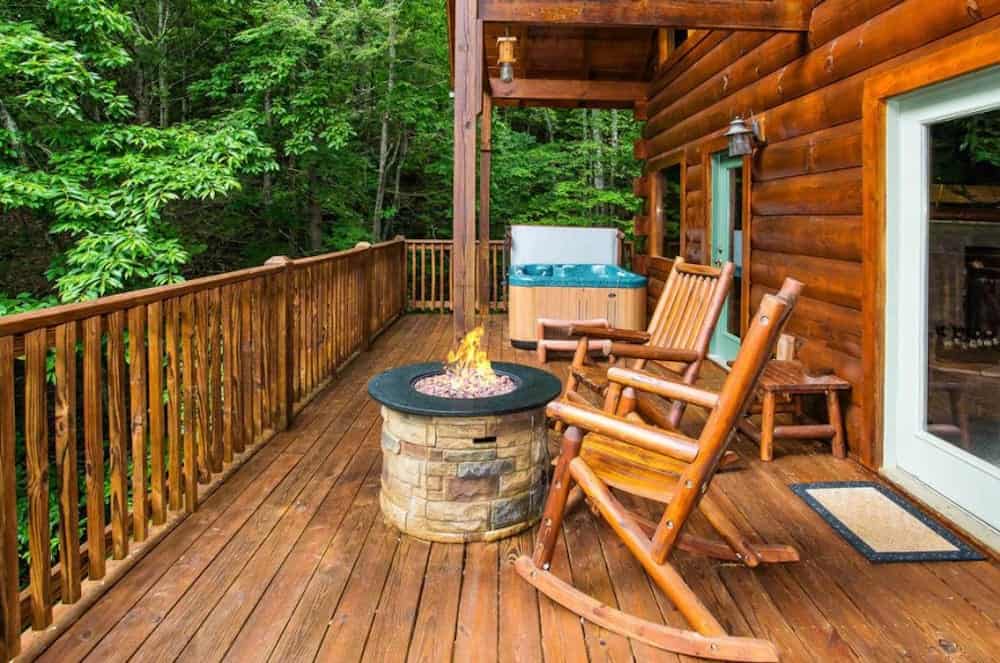 secluded cabin rentals deck with a firepit and rocking chairs